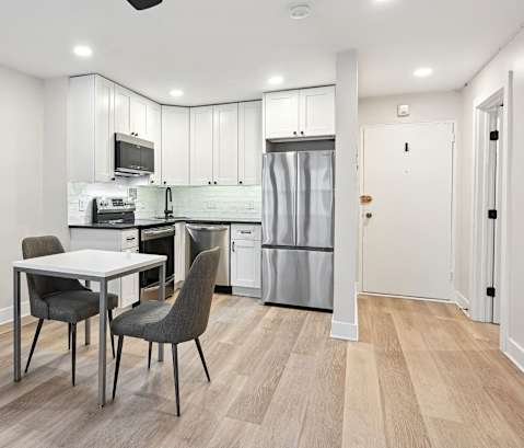 a living room and kitchen with a table and chairs