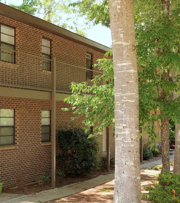 a brick apartment building with a staircase and a tree
