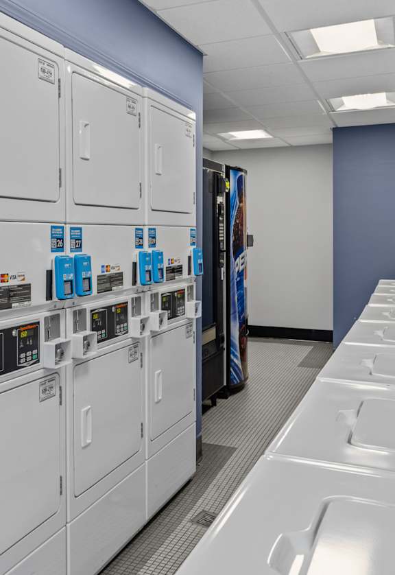 a row of gray lockers in a room with a clock on the wall