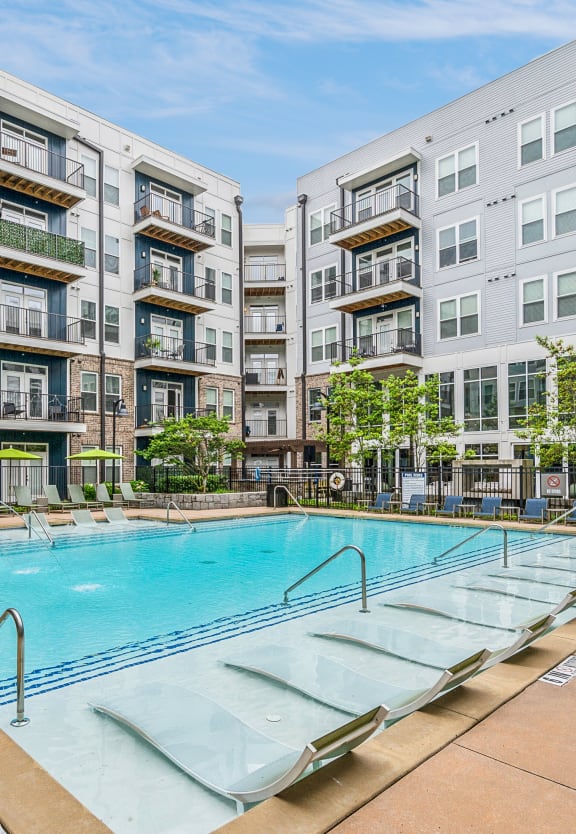 a large swimming pool with chaise lounge chairs in front of an apartment building at Glenwood at Grant Park Apartments, Atlanta, 30316