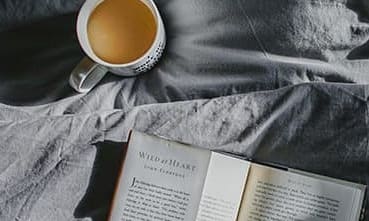 Coffee and book on bed