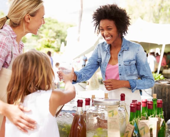 Woman Selling Soft Drinks at Outdoor Farmer's Market