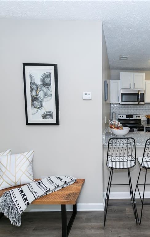 a kitchen and living room with a bar and stools