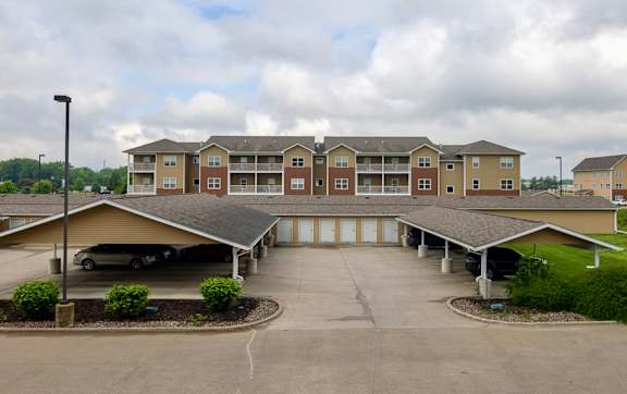 A parking lot in front of apartment buildings. at Deer Valley Apartments, Silvis, IL