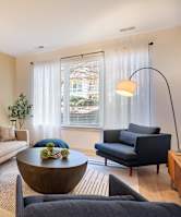 A living room with a couch, a chair, a table, and a television.