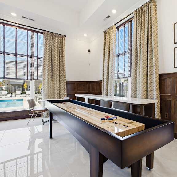 A pool table in a room with a window and curtains.