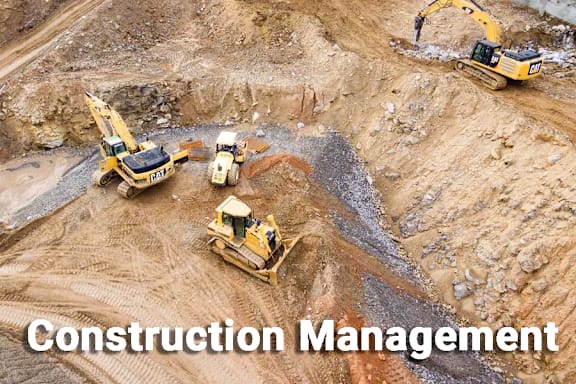 A construction site with several yellow excavators working on the ground.