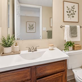 A bathroom with a white sink and a white toilet.