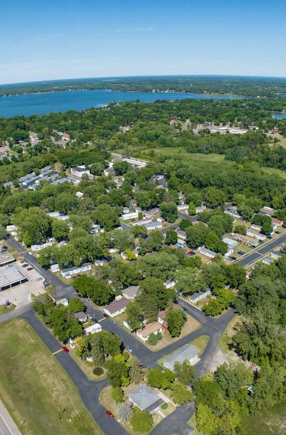 an aerial view of a neighborhood with trees and a parking lot
