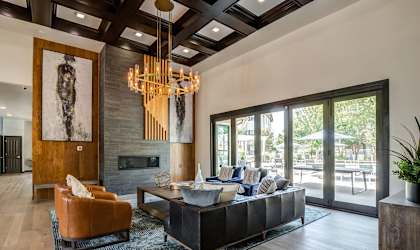 a living room with a leather couch and a chandelier