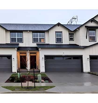 A large house with a grey roof and a brown door.