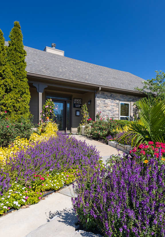 A welcoming view of the Cedar Crest clubhouse exterior, highlighting the entrance and landscaped grounds.