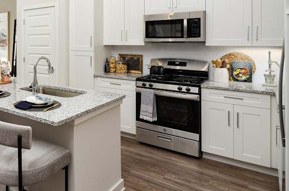 an open kitchen and living room with a large island with stools