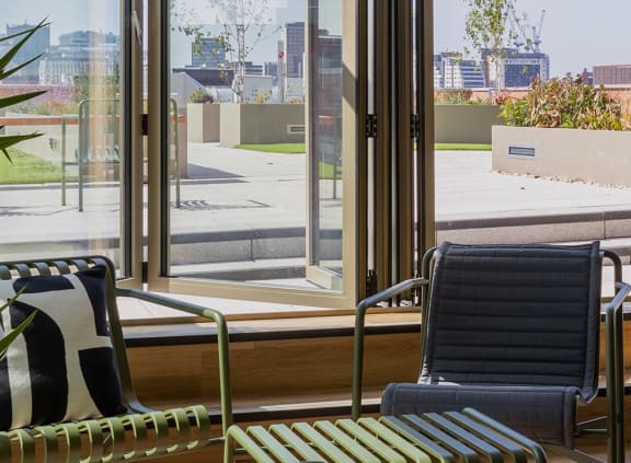 a lounge chair in front of a large window in a hotel lobby