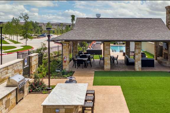 A patio area with a table and chairs is surrounded by a fence.