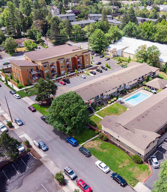 a view from above of a building with a pool and parking lot