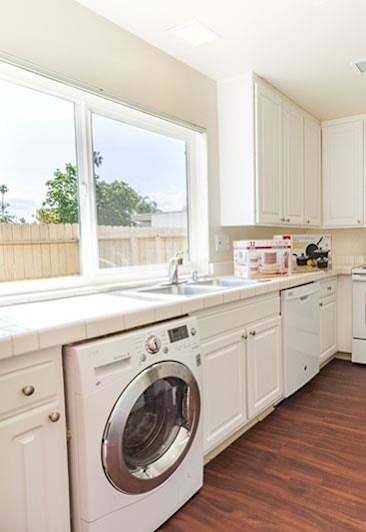 kitchen with white cabinets and white appliances, also washer/dryer combo