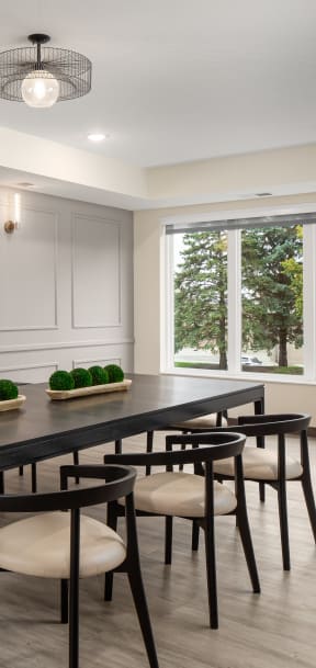 a dining room with a table and chairs and a large window