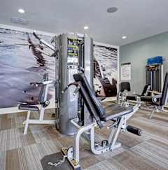 A gym with a variety of equipment including a leg press machine.