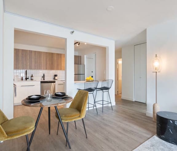 a living room and dining room with a table and chairs