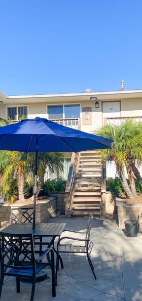 courtyard with table and chairs and an umbrella