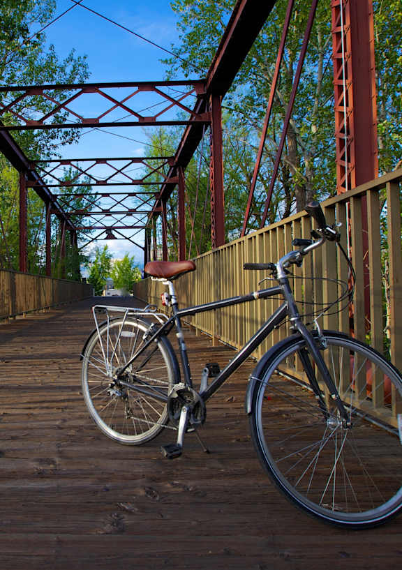 A bicycle is parked on a wooden bridge.