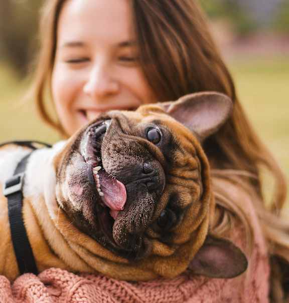 a woman holding a dog in her arms