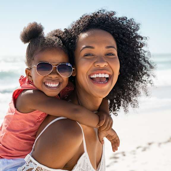 A woman and a child are enjoying a day at the beach.