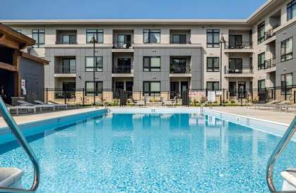 a swimming pool with an apartment building in the background at Two Points Crossing, Madison, WI, 53593