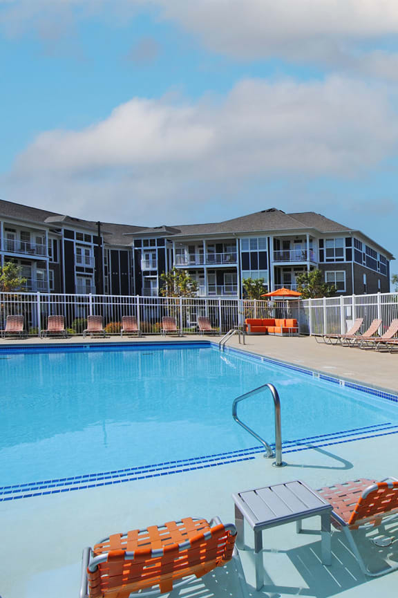 our apartments have a large swimming pool with orange chairs