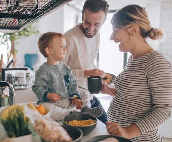 a family gathered around a kitchen counter preparing food