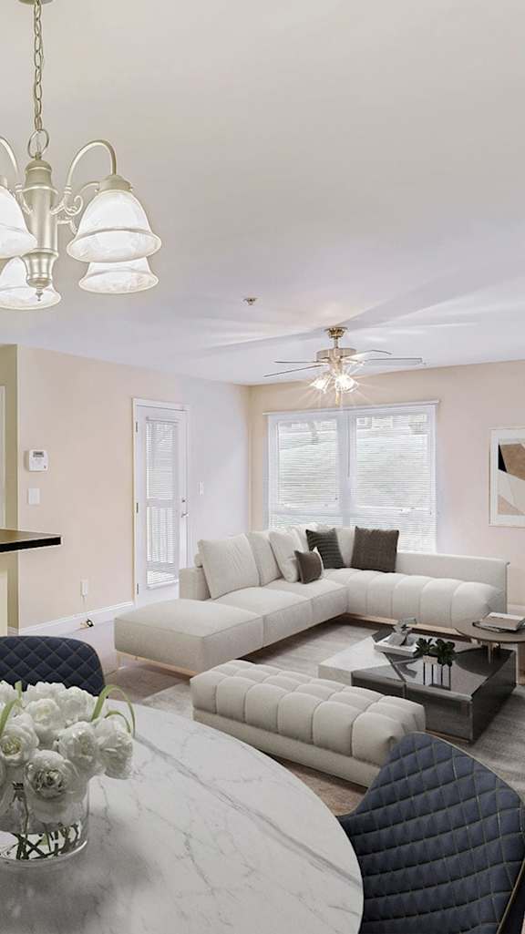 A modern living room with a grey sofa, a coffee table, and a painting on the wall.