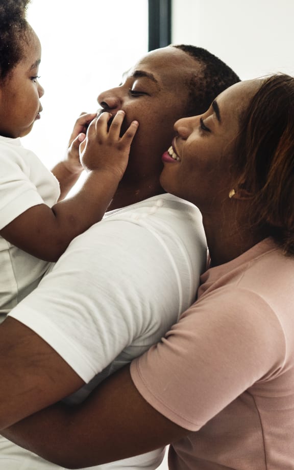a mother and father holding a baby in a hospital room