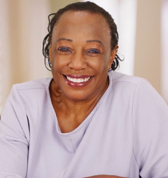 a woman smiling while sitting on a couch