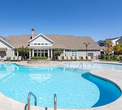 A large swimming pool in front of a house.