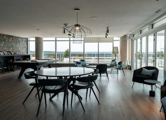 Modern dining room with round table and seating at Baseline Apartments, Ottawa, Ontario