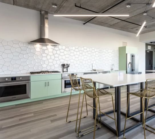 a kitchen with a long white table and chairs