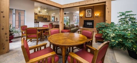 a Clubhouse lobby with a fireplace and a table with chairs with a stone kitchen island