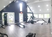 Thumbnail 8 of 24 - a gym with exercise equipment and windows in a building