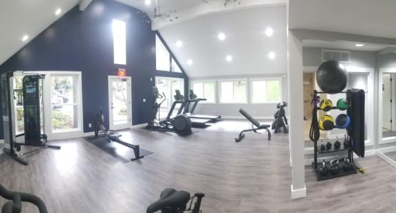 a gym with exercise equipment and windows in a building