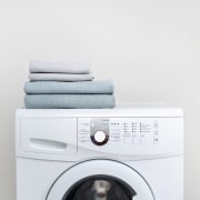 a white washing machine with towels on top of it