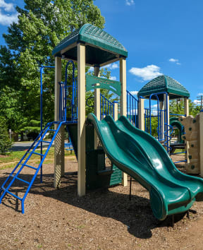 a playground with a slide and climbing equipment in a park