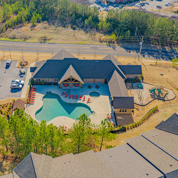 A bird's eye view of a residential area with a swimming pool and a house.
