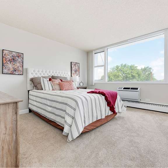 a bedroom with a bed and a large window