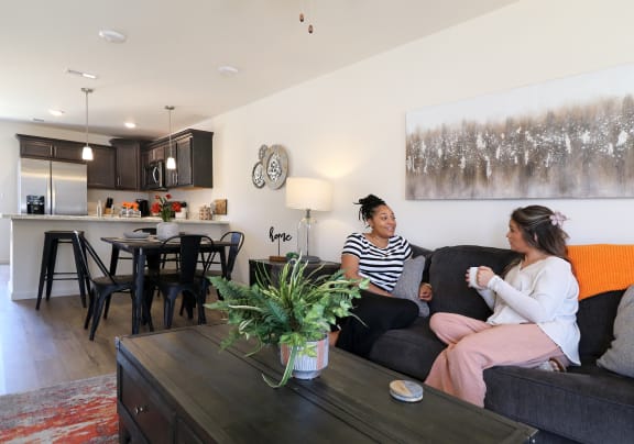 a kitchen and living room with a large clock on the wall