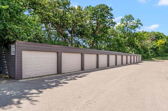 a long parking lot with cars parked in front of a building
