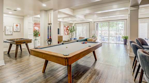 A pool table is in the middle of a room with a lot of space.