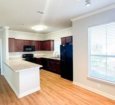 an empty kitchen with wood floors and a large window