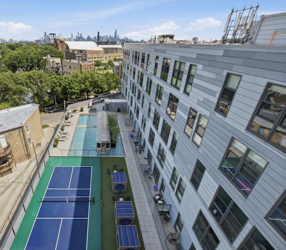 A tennis court is located on the roof of a building.
