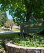 a sign that says campus village with a building in the background
